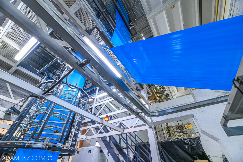 maszyny przemysłowe na hali produkujące niebieską folię